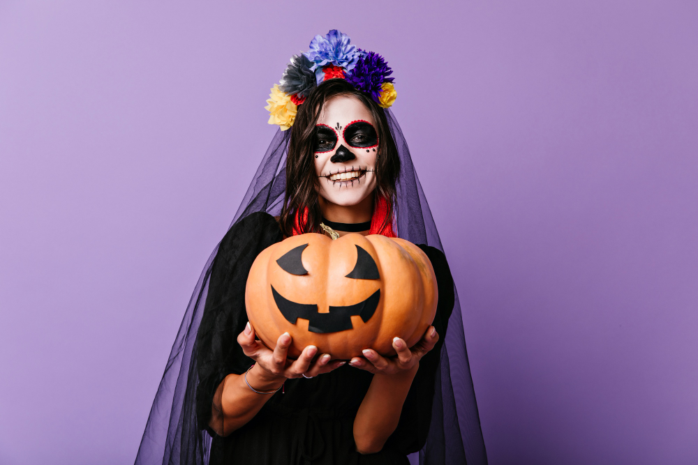 smiling zombie girl black veil posing pastel wall glad woman dead bride outfit holding halloween pumpkin
