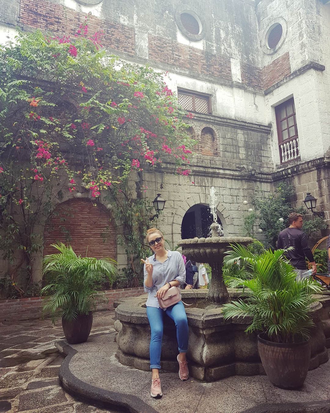 Mulher posando em um jardim na Casa Manila