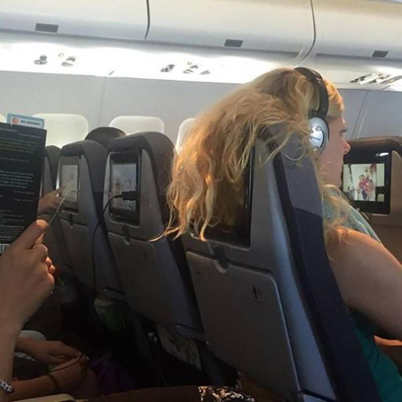 Mulheres cobrindo a tv do avião com o cabelo