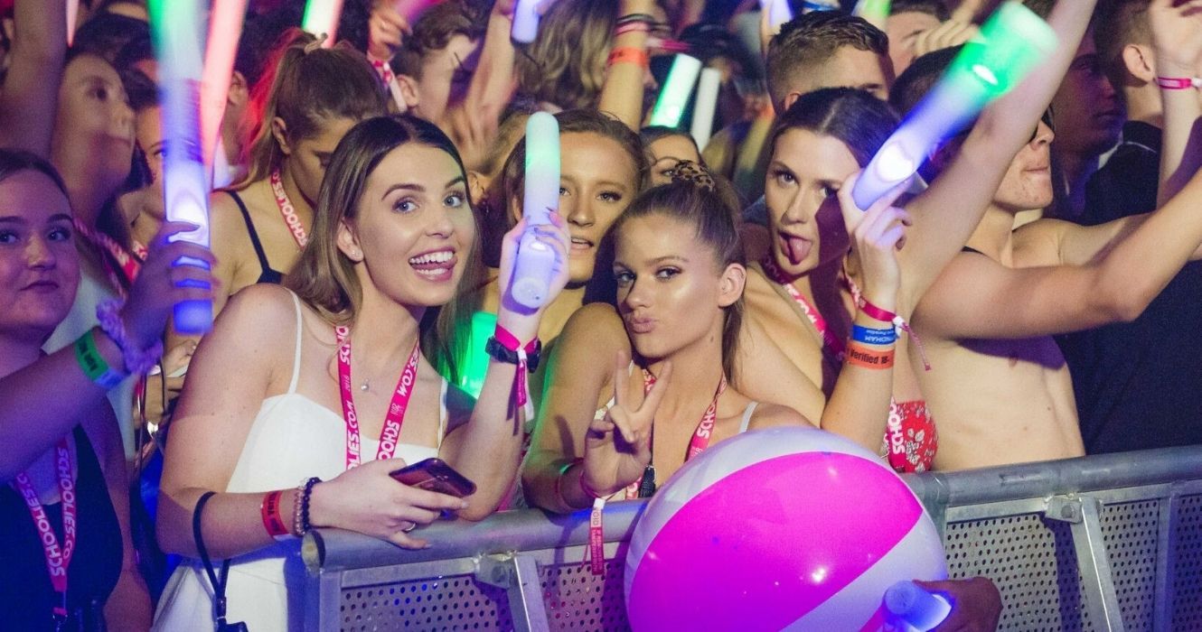 meninas em uma festa posando com bastões luminosos