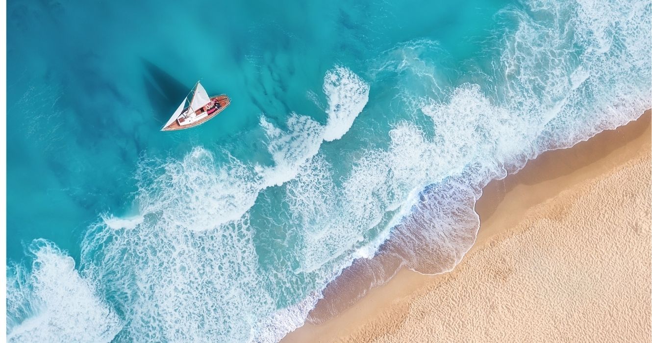uma vista aérea de um veleiro em uma praia do Caribe