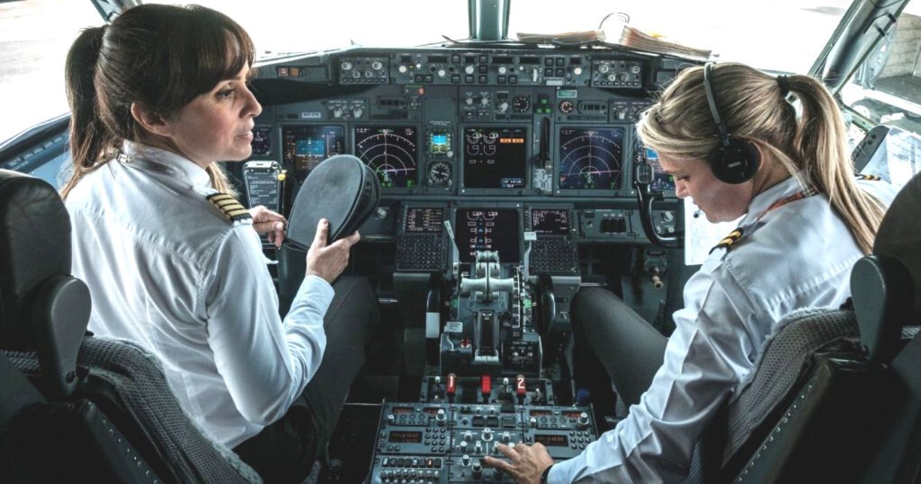 Duas pilotos do sexo feminino completando uma verificação pré-voo na cabine do avião