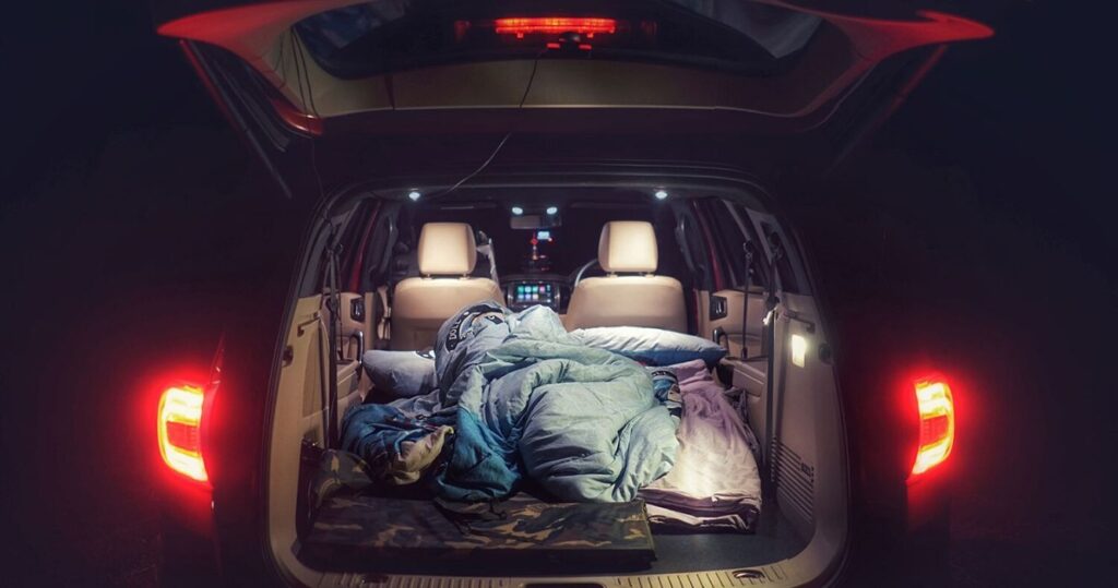 Car in nighttime with bedding in the back trunk