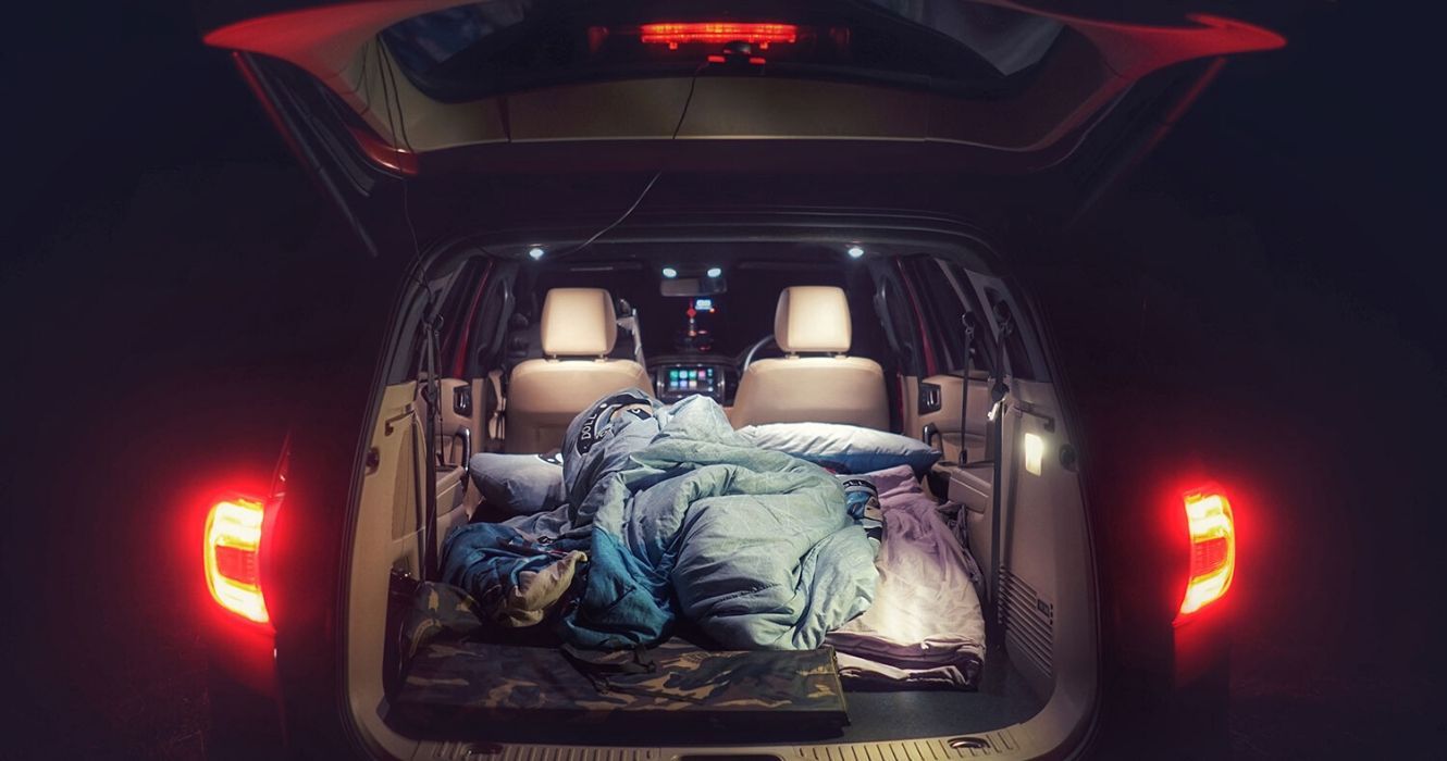 Carro à noite com roupa de cama no porta-malas