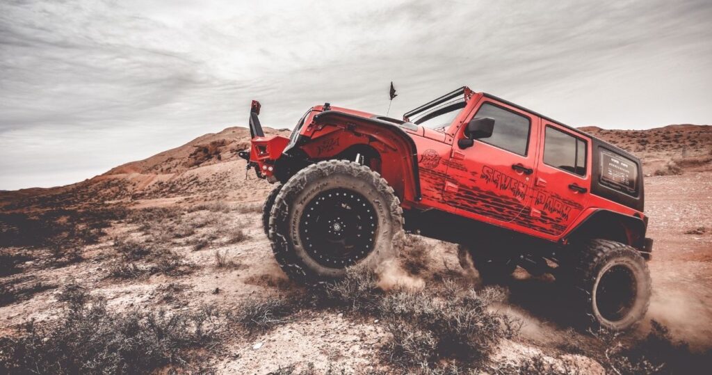 a red jeep going off-roading
