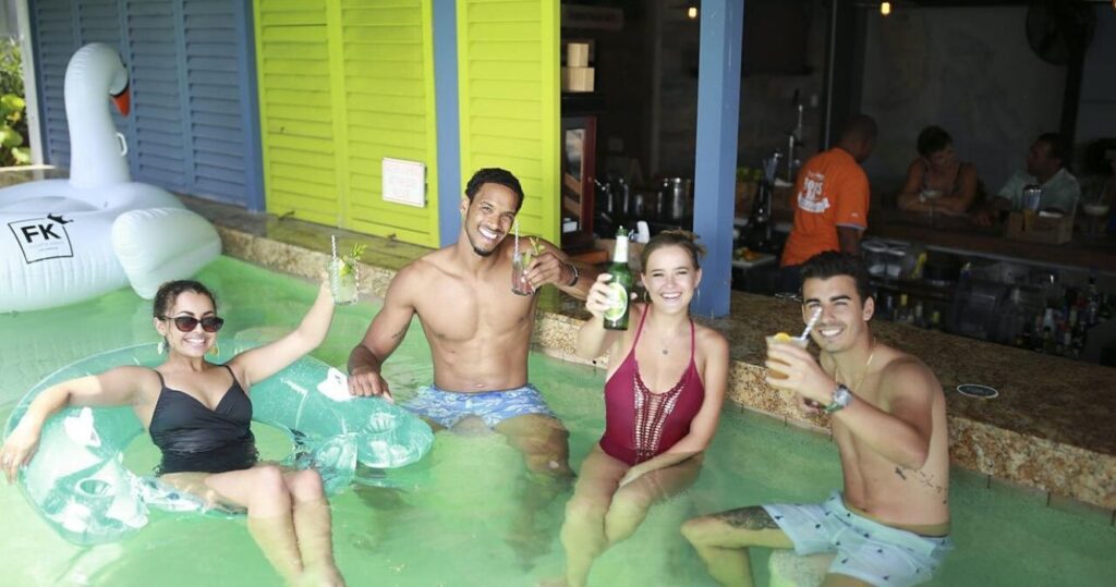 Four people in a pool at a swim up bar in a Bahamas resort