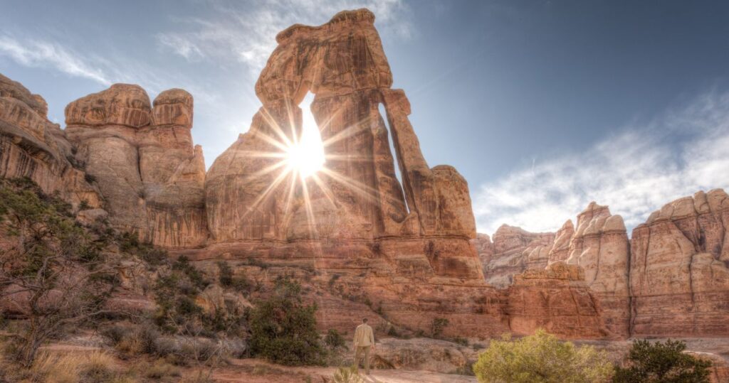 sun shining through Druid Arch in the canyonlands, utah