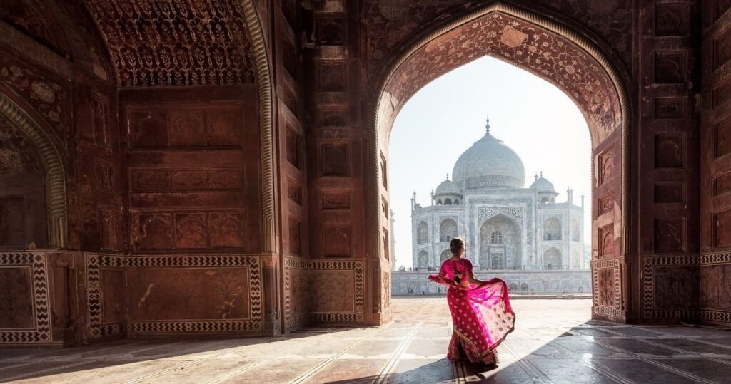 a woman in a red saree at the taj mahal