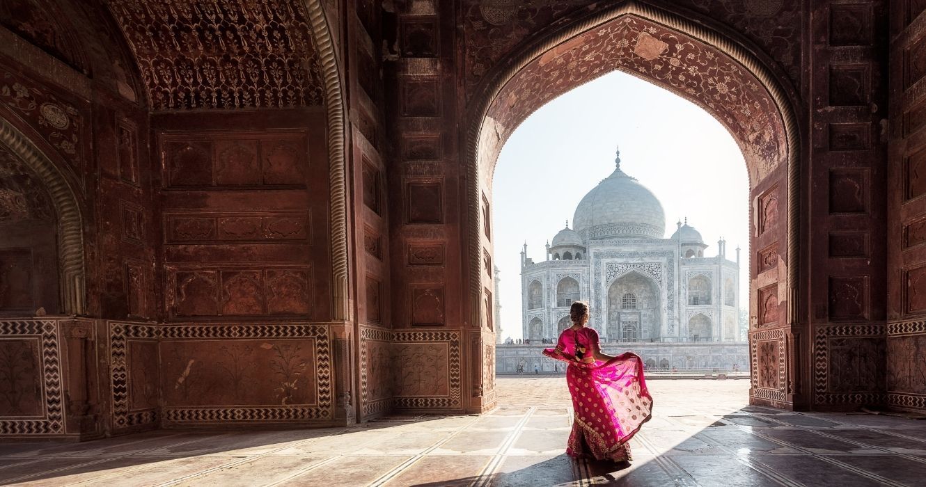 uma mulher em um saree vermelho no taj mahal