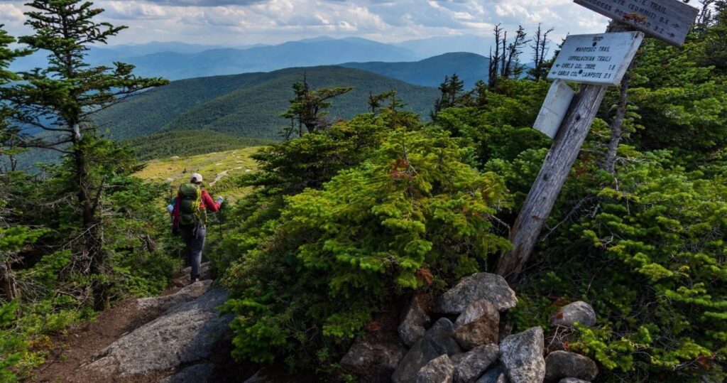 a hiker on a mountain summit in maine