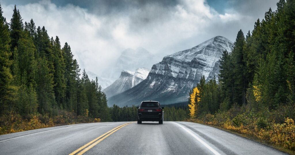 a car driving through the mountains and forest