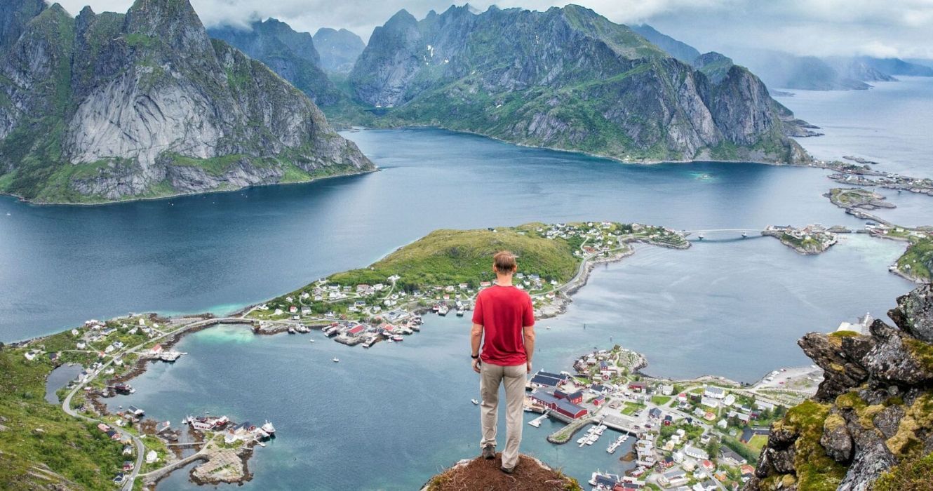 um homem fica em um penhasco nas ilhas lofoten, noruega