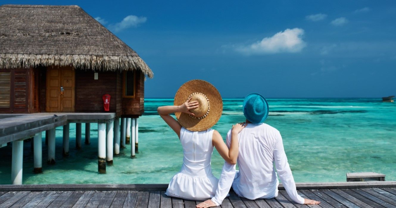 Casal em um cais de praia tropical nas Maldivas