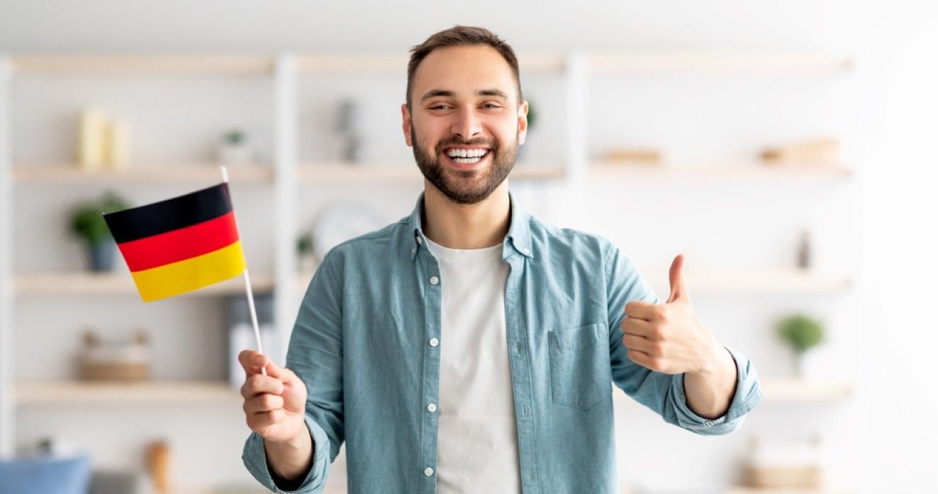 Homem feliz acenando a bandeira alemã