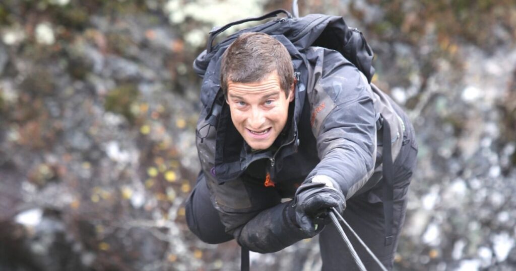 Bear Grylls climbing on a rope